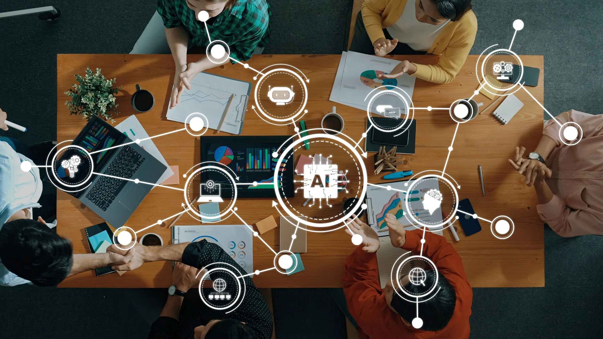 Overhead view of a diverse team around a wooden table, collaborating with laptops, charts, and AI holographic graphics projected above the workspace.